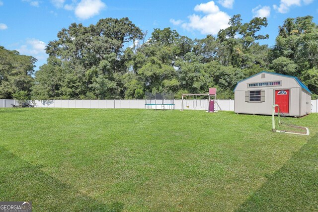 view of yard featuring a fenced in pool and an outbuilding