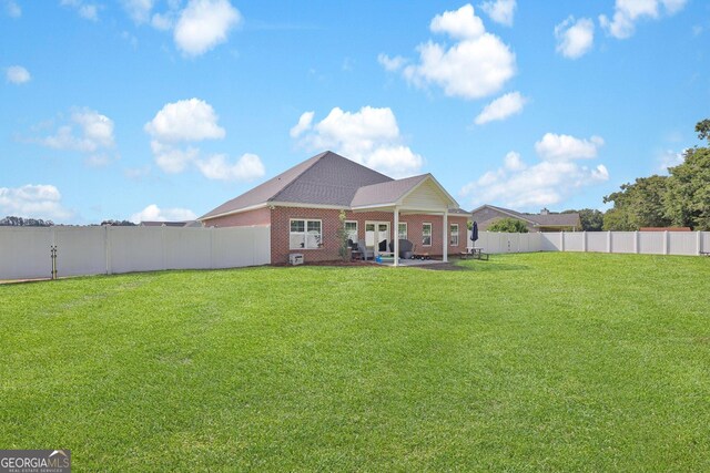 back of property featuring a patio and a yard