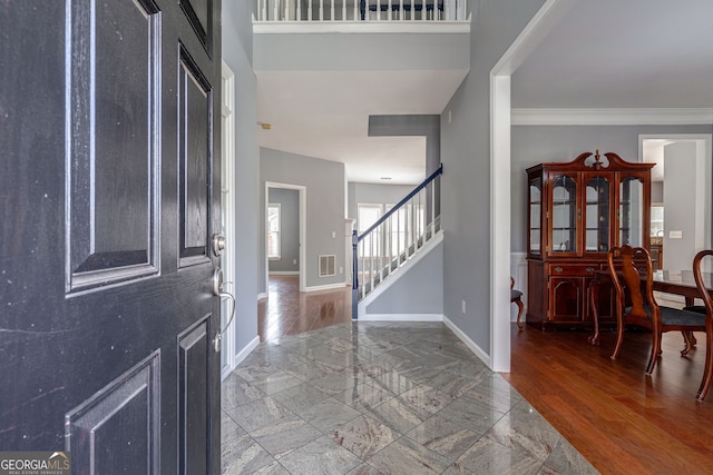 foyer with hardwood / wood-style floors and crown molding