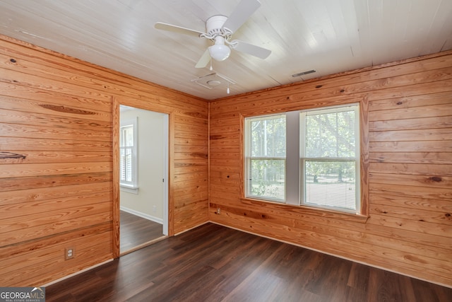 unfurnished room featuring hardwood / wood-style flooring, plenty of natural light, wood walls, and ceiling fan