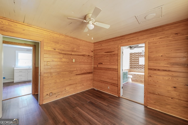 spare room featuring ceiling fan, wood walls, and hardwood / wood-style floors