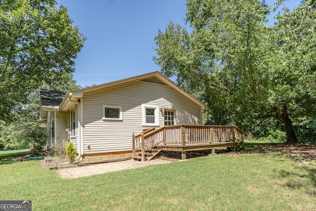 rear view of house with a yard and a deck