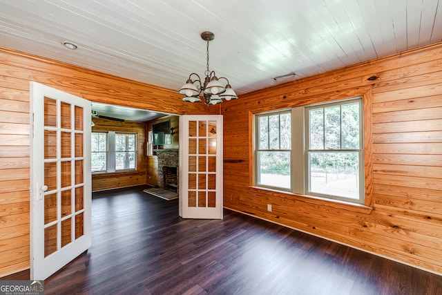 interior space featuring a chandelier, wooden walls, french doors, wooden ceiling, and hardwood / wood-style flooring