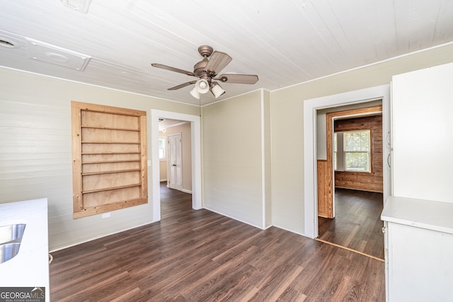 spare room with dark hardwood / wood-style flooring, built in features, and ceiling fan