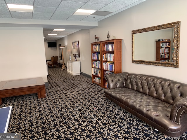 living room featuring carpet flooring and a drop ceiling