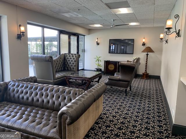 interior space with a paneled ceiling and baseboards