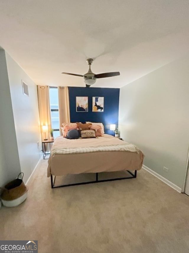 bedroom featuring light carpet, baseboards, visible vents, and ceiling fan