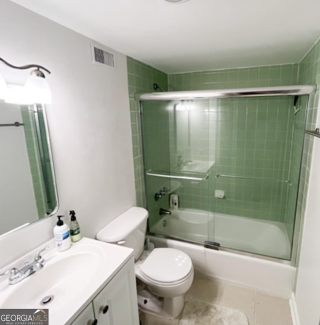 full bathroom with shower / bath combination with glass door, visible vents, toilet, vanity, and tile patterned floors