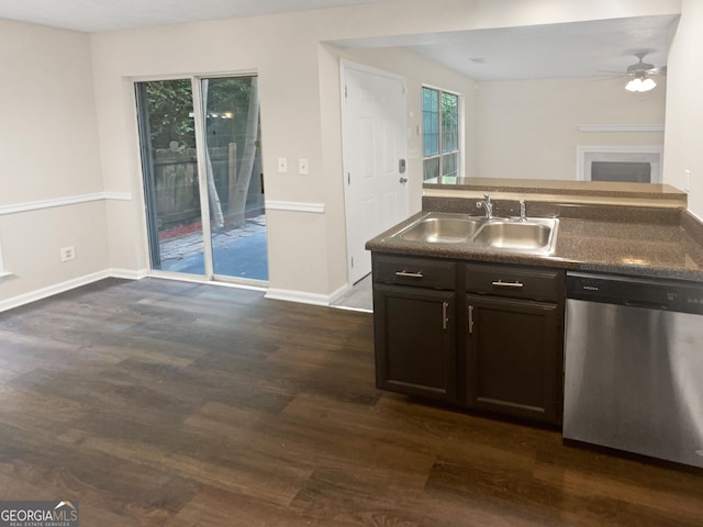 kitchen with dark wood-type flooring, a sink, open floor plan, dishwasher, and dark countertops