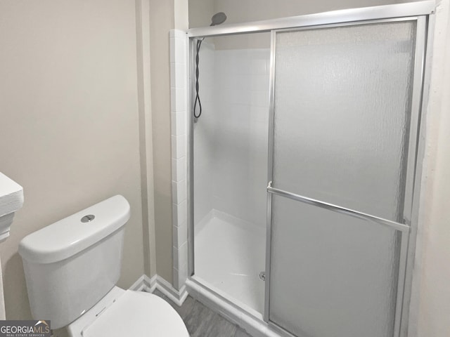 bathroom with a shower stall and toilet