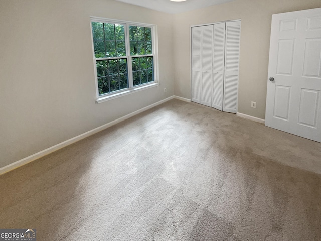 unfurnished bedroom featuring carpet floors, a closet, and baseboards