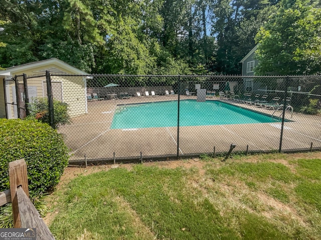 community pool with a yard and fence