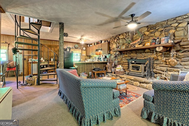 605 W Wildcat Rd, Clarkesville, GA 30523 - living area with a ceiling fan, a wood stove, wooden walls, and light colored carpet
