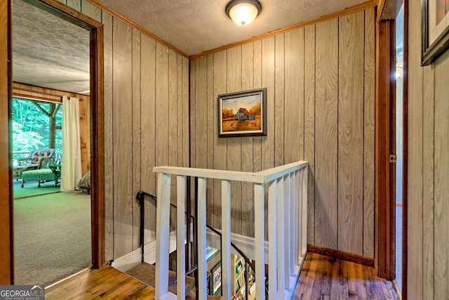 605 W Wildcat Rd, Clarkesville, GA 30523 - hall with a textured ceiling, crown molding, an upstairs landing, wooden walls, and wood finished floors