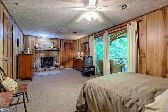 605 W Wildcat Rd, Clarkesville, GA 30523 - carpeted bedroom with wooden walls, a textured ceiling, and a brick fireplace