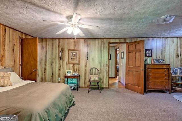 605 W Wildcat Rd, Clarkesville, GA 30523 - carpeted bedroom with wood walls, a textured ceiling, and a ceiling fan
