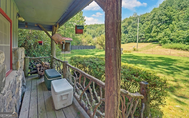 wooden terrace featuring a lawn