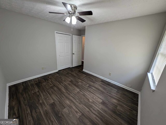 unfurnished bedroom featuring ceiling fan, wood-type flooring, a textured ceiling, and a closet