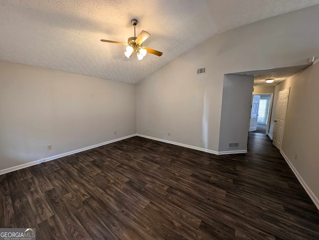 spare room with dark hardwood / wood-style flooring, vaulted ceiling, a textured ceiling, and ceiling fan