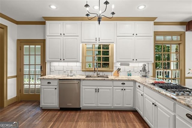 kitchen with plenty of natural light, stainless steel appliances, an inviting chandelier, and tasteful backsplash