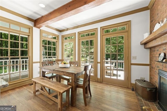 sunroom with beamed ceiling and a fireplace