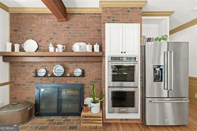 kitchen featuring appliances with stainless steel finishes, white cabinetry, dark hardwood / wood-style flooring, and crown molding