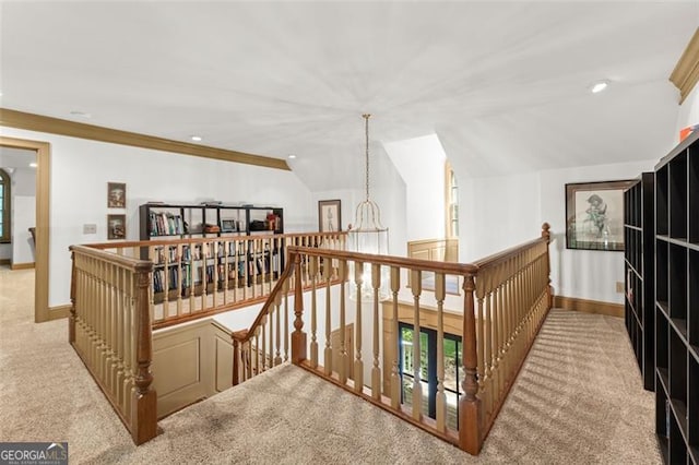 hallway featuring ornamental molding, carpet, an inviting chandelier, and vaulted ceiling