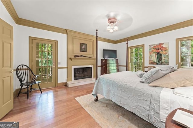 bedroom with crown molding, ceiling fan, multiple windows, and light hardwood / wood-style floors