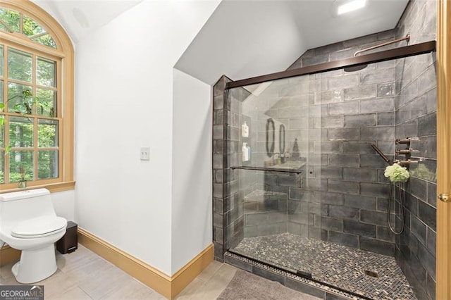 bathroom featuring lofted ceiling, toilet, tile patterned floors, and walk in shower