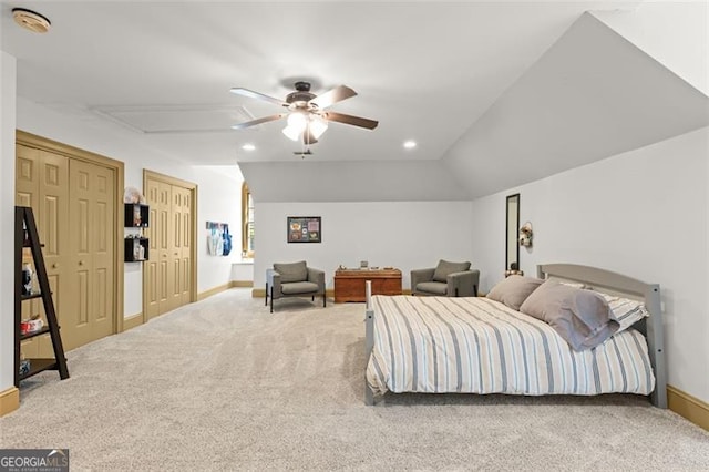 carpeted bedroom with vaulted ceiling, two closets, and ceiling fan