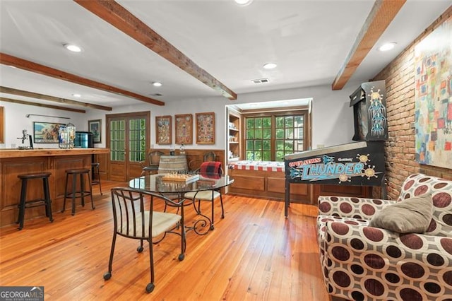 dining room featuring light hardwood / wood-style flooring and beamed ceiling