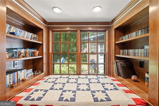 living area with built in features and ornamental molding