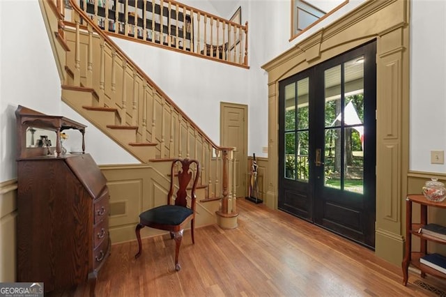 foyer entrance featuring a high ceiling, wood-type flooring, and french doors