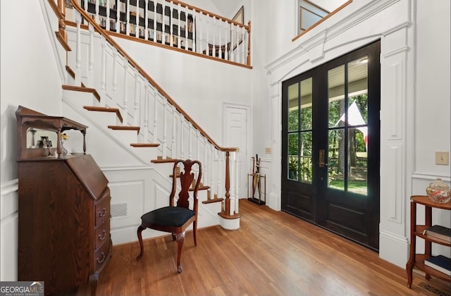 foyer entrance featuring a high ceiling, hardwood / wood-style floors, and french doors