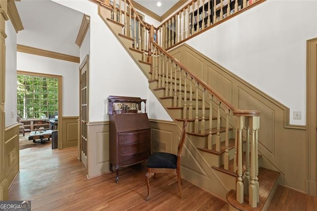 staircase featuring crown molding and hardwood / wood-style floors