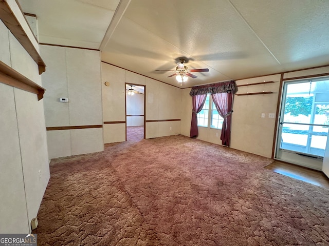 carpeted empty room with ceiling fan and a textured ceiling