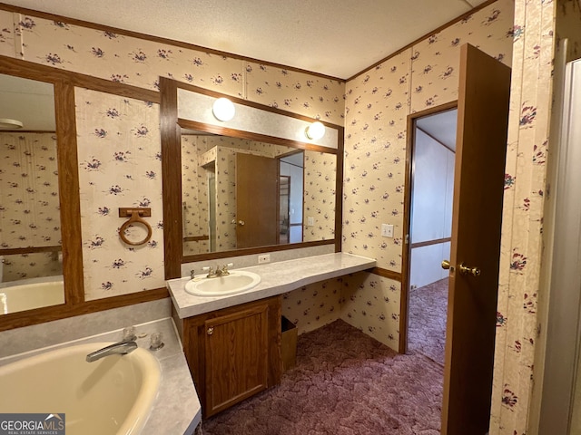 bathroom featuring a tub to relax in, a textured ceiling, and vanity