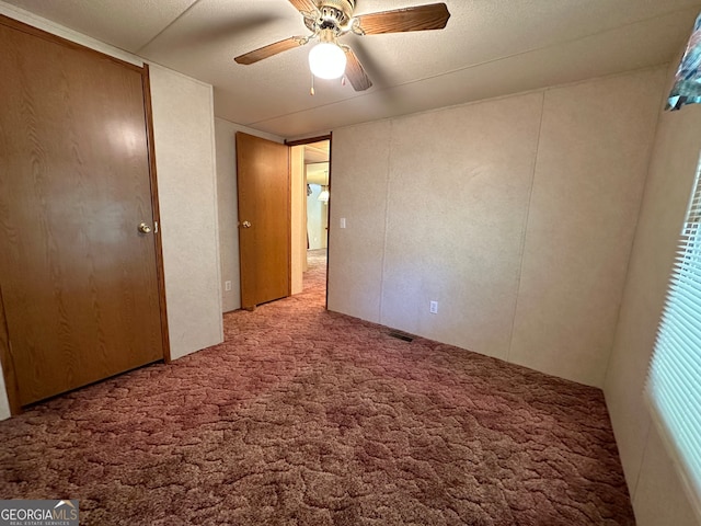 unfurnished bedroom featuring ceiling fan and light carpet