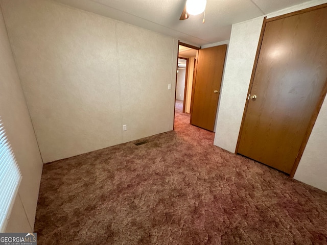 unfurnished bedroom with ceiling fan and carpet