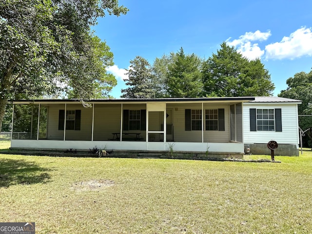 view of front of home featuring a sunroom and a front lawn