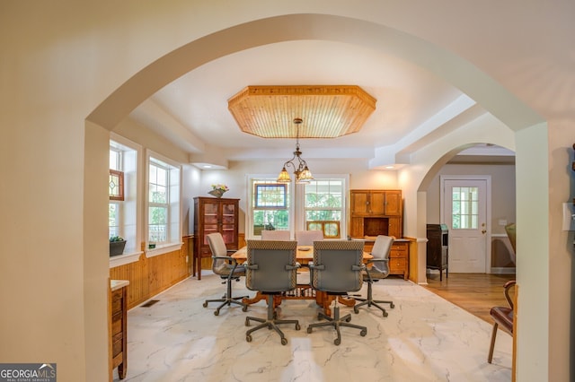 dining room with light hardwood / wood-style floors, a tray ceiling, and a chandelier