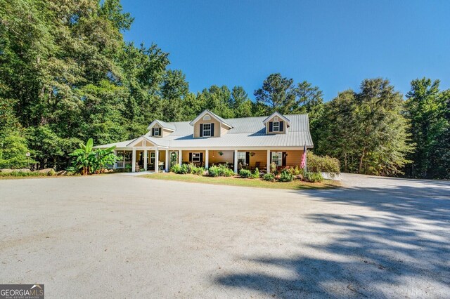 cape cod house featuring covered porch