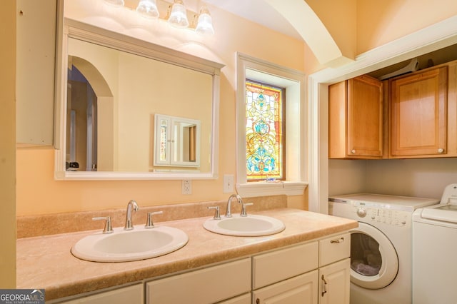 laundry room featuring washer and dryer, sink, and cabinets