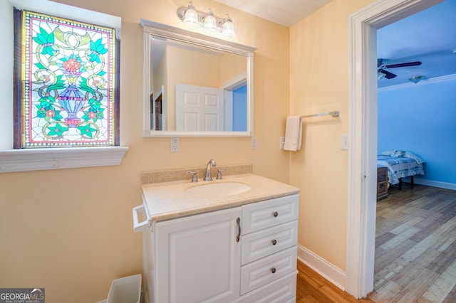 bathroom featuring ceiling fan, hardwood / wood-style floors, crown molding, and vanity