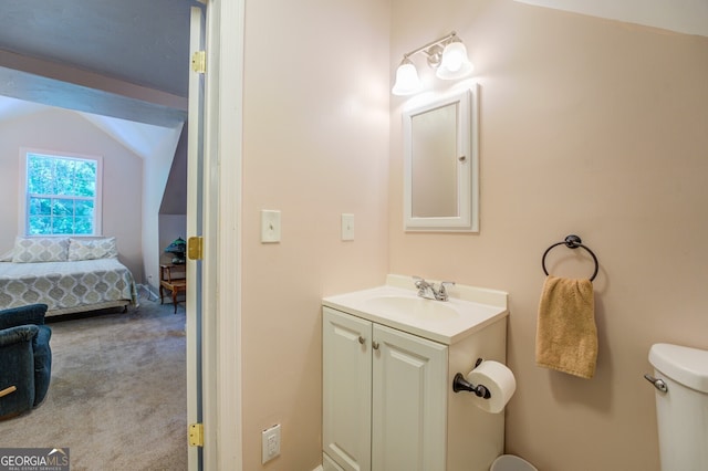 bathroom featuring toilet, vaulted ceiling, and vanity