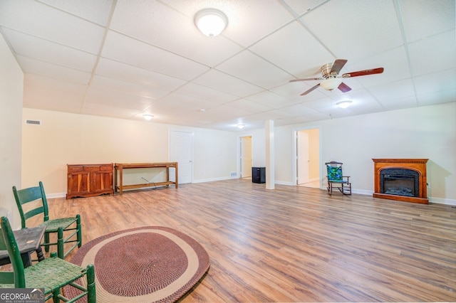 sitting room featuring ceiling fan, light hardwood / wood-style flooring, and a paneled ceiling