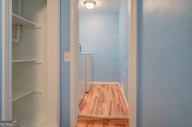 interior space featuring washing machine and clothes dryer and hardwood / wood-style floors