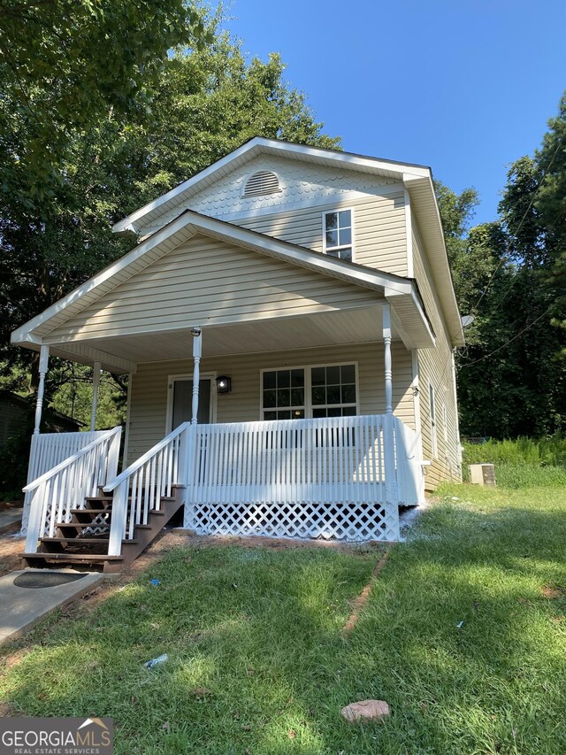 view of front of house with a front yard and covered porch