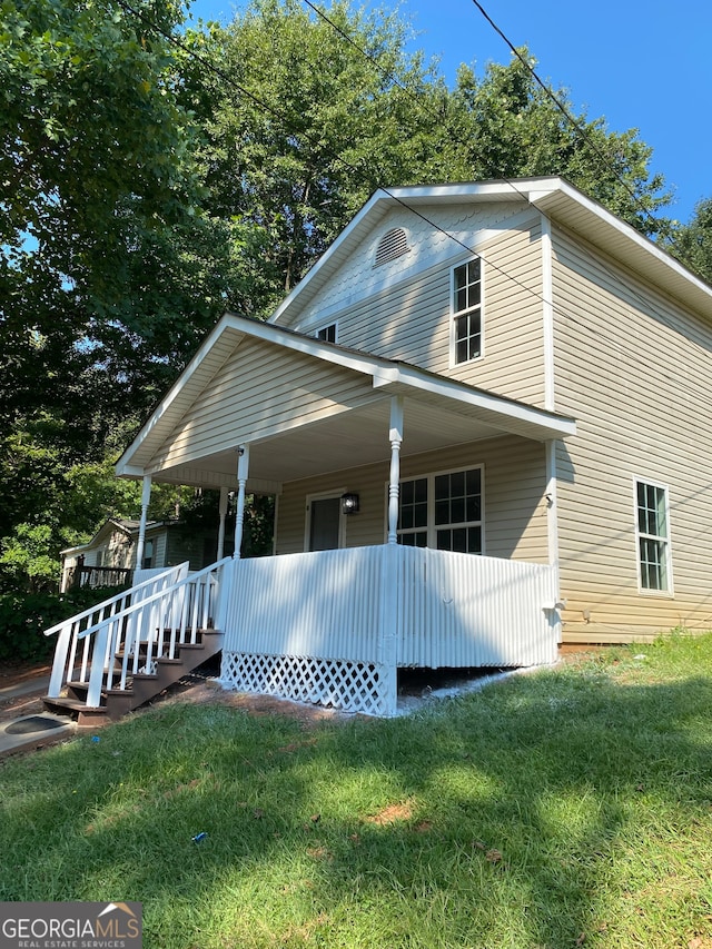 view of front of house with a porch and a front yard