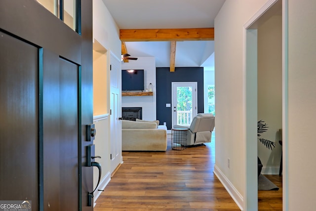 entryway featuring a fireplace, hardwood / wood-style flooring, and beamed ceiling